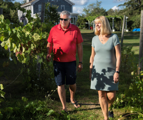 Mike and woman walking through vineyard