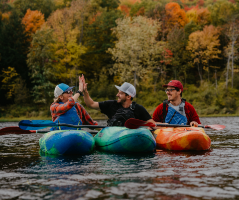 three people on kayaks on river