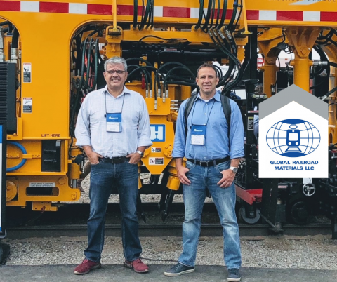 two men standing in front railroad materials